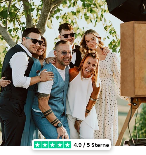 Ein Gruppe Partygäste hat Spaß mit einer gemieteten Fotobox
